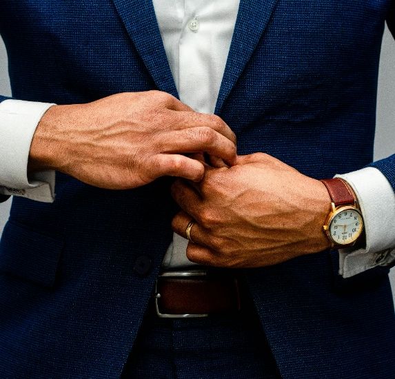 A man dressed in a blue suit and white shirt, exuding professionalism and style.